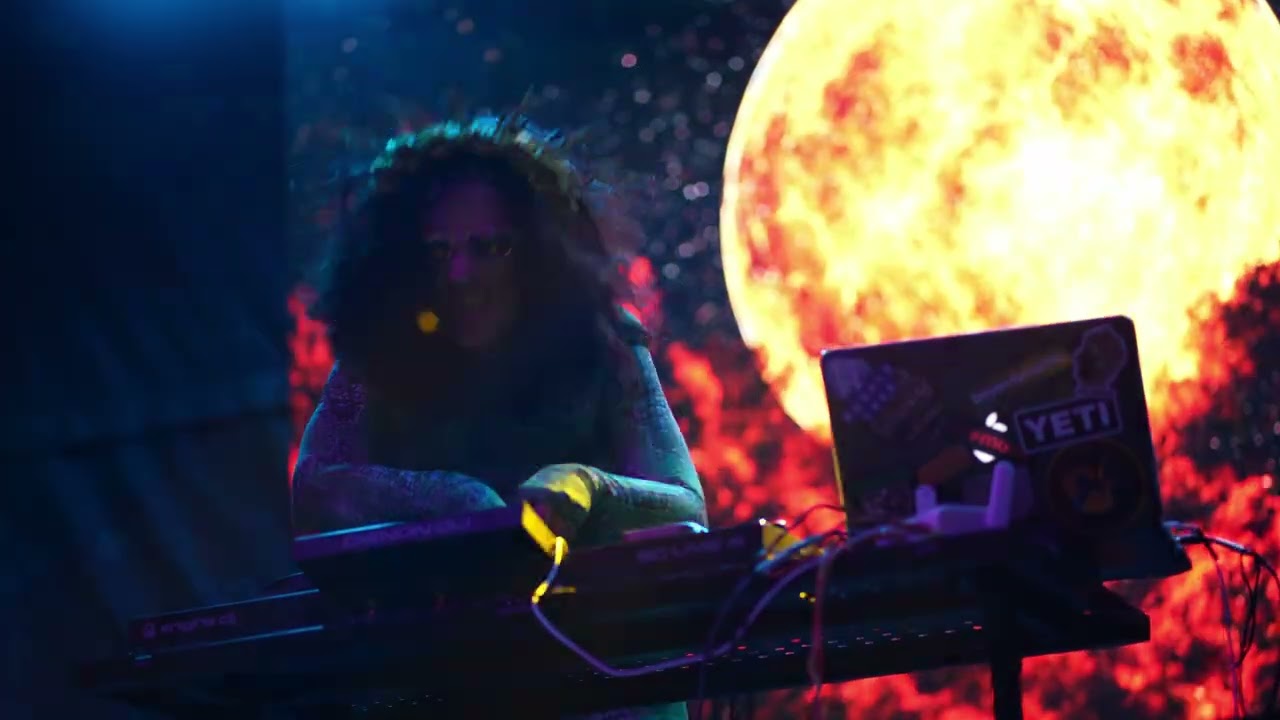Performer at a keyboard in front of a moon projection